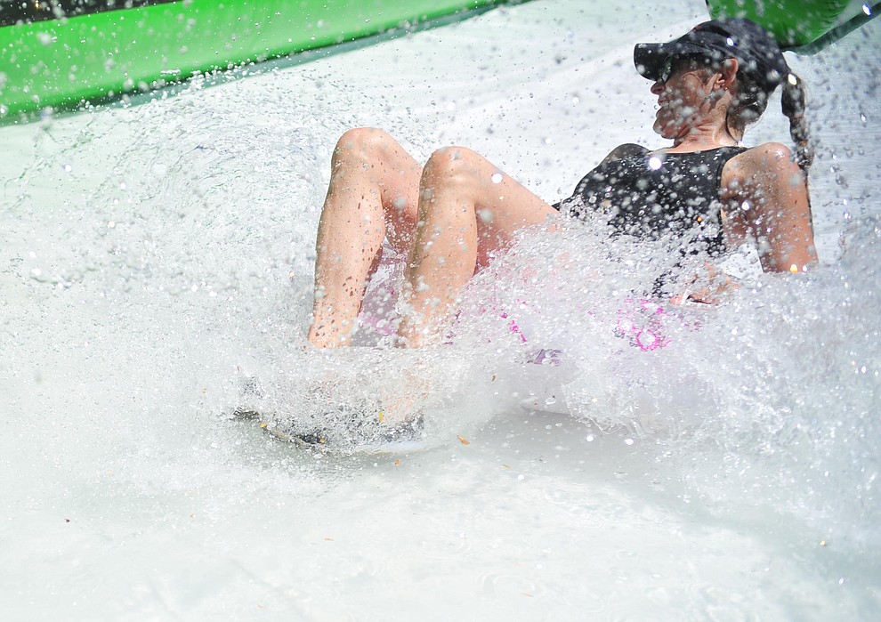 Lori Reynolds on the slide at the annual Monsoon Festival with the water slide that stetches most of the length of Union Street Saturday, August 17, 2019, in downtown Prescott. (Les Stukenberg/Courier)