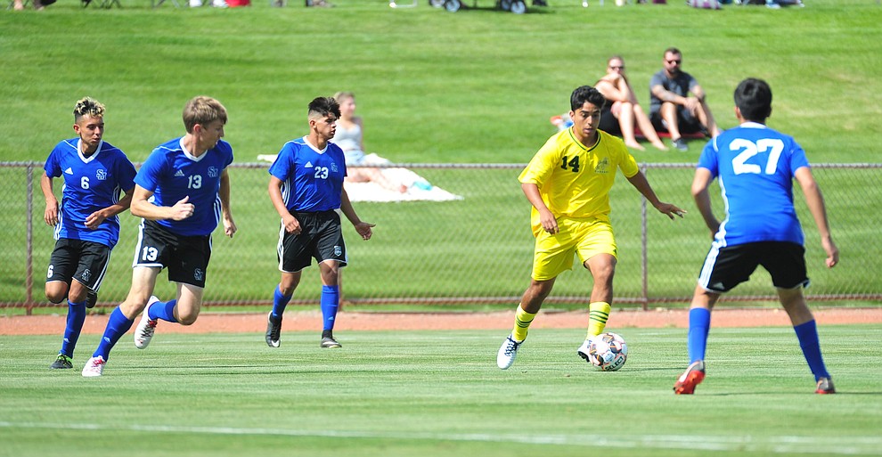 Yavapai's Jonathan Mayen moves the ball between defenders as the Roughriders host South Mountain Community College Thursday, August 22, 2019, in Prescott Valley. (Les Stukenberg/Courier)