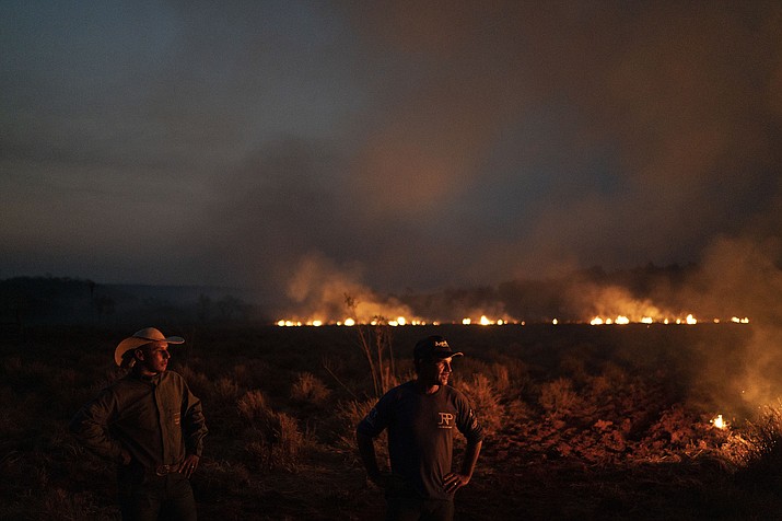 Neri dos Santos Silva, center, watches an encroaching fire threat after digging trenches to keep the flames from spreading to the farm he works on, in the Nova Santa Helena municipality, in the state of Mato Grosso, Brazil, Friday, Aug. 23, 2019. Under increasing international pressure to contain fires sweeping parts of the Amazon, Brazilian President Jair Bolsonaro on Friday authorized use of the military to battle the massive blazes. (Leo Correa/AP)