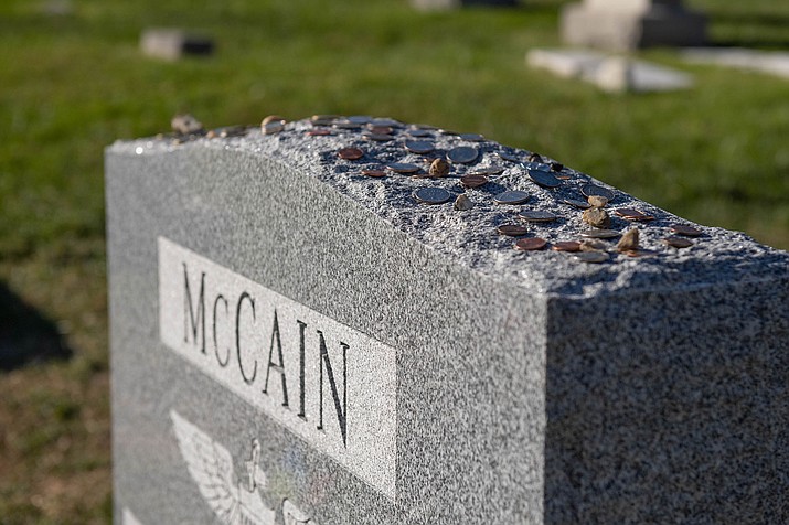 Former Sen. John McCain’s grave at the U.S. Naval Academy is next to friend and former classmate, Adm. Chuck Larson. Since his death a year ago, McCain’s grave has become a stop for visitors who leave mementos. (Stacy Godfrey/USNA, via Cronkite News)