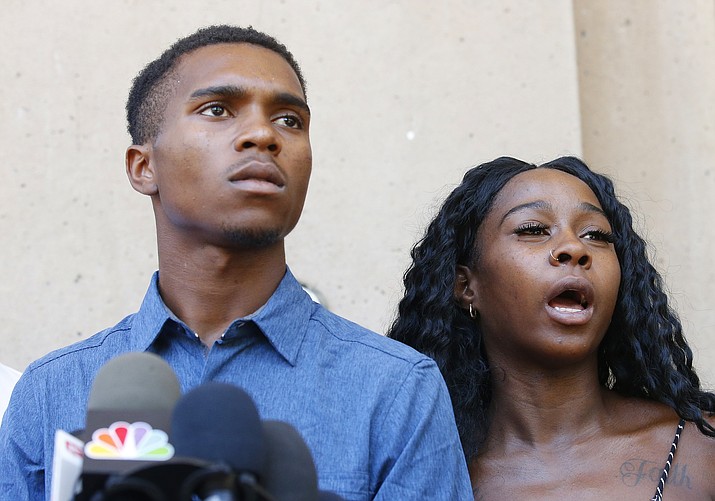Iesha Harper, right, answers a question during a news conference as she is joined by her fiancee Dravon Ames, left, at Phoenix City Hall, Monday, June 17, 2019, in Phoenix. Ames and his pregnant fiancée, Harper, had guns aimed at them by Phoenix police during a response to a shoplifting report. On Thursday, Aug. 29, 2019, Ames was booked into jail for driving on a suspended license. DPS spokesman Raul Garcia says Ames was pulled over for going 85 mph in a 55 mph speed zone shortly after midnight. (Ross D. Franklin/AP, file)