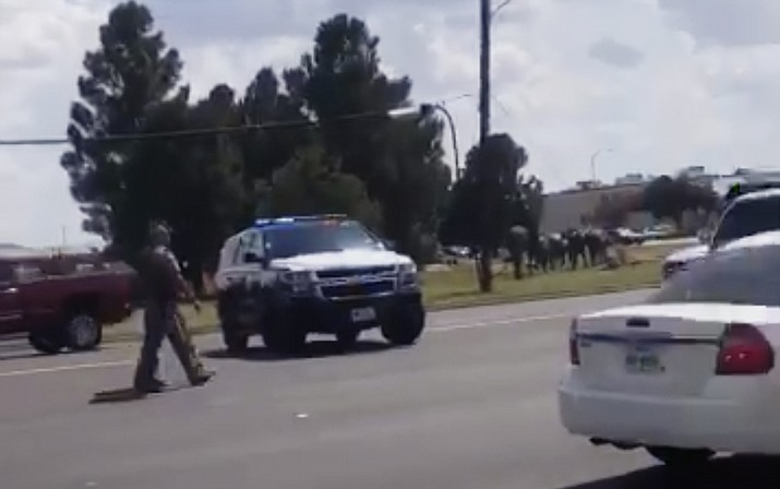 In this image made from video provided by Dustin Fawcett, police officers guard on a street in Odessa, Texas, Saturday, Aug. 31, 2019. Police said there are "multiple gunshot victims" in West Texas after reports of two suspects opening fire on Saturday in the area of Midland and Odessa. (Dustin Fawcett via AP)