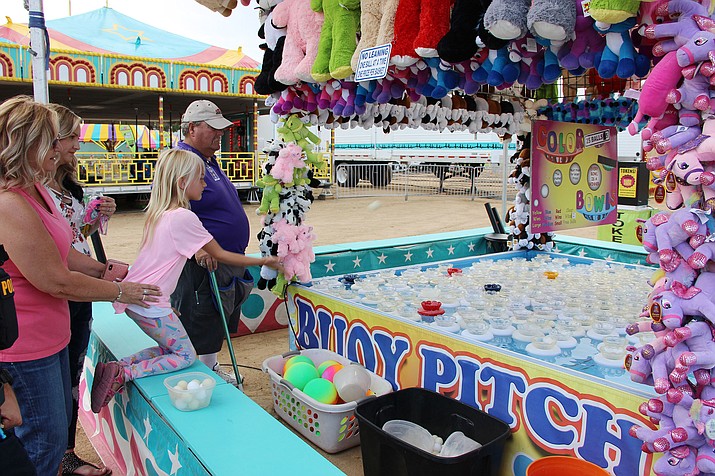 Leah Kite plays Buoy Pitch at the Yavapai County Fair Thursday, Sept. 5, 2019. With her were her mother, Ariel Sugahara, her father, Zac Sugahara and grandmother Angela Chunglo. (Max Efrein/Courier)
