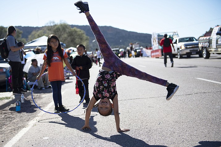 In this Sept. 8, 2018 image, Tomica Johnson, 8, of Fort Defiance, Arizona, does cartwheels during the Navajo Nation Fair Parade near Tse Bonito, New Mexico. (Alma E. Hernandez/Gallup Independent via AP)