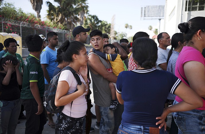 In this Aug. 1, 2019 file photo, migrants line up in Matamoros, Mexico, for a meal donated by volunteers from the U.S., at the foot of the Puerta Mexico bridge that crosses to Brownsville, Texas. A federal appeals court has put on hold a ruling that blocked a Trump administration policy that would prevent migrants from seeking asylum along the entire southwest border. The 9th U.S. Circuit Court of Appeals issued a stay Tuesday, Sept. 10, 2019 that put the ruling by U.S. District Judge Jon Tigar on hold for now. That means the administration's asylum policy is blocked in the border states of California and Arizona but not in New Mexico and Texas. (Emilio Espejel/AP, File)