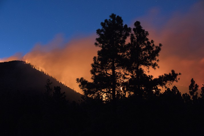 In this July 21, 2019, file photo, a wildfire burns through the Coconino National Forest, north of Flagstaff, Ariz. Officials say the wildfire likely was started by a spark from a piece of heavy equipment striking a rock during a forest-thinning project. Coconino National Forest officials say an excavator working on steep slopes hit a rock, creating a heat source that stayed underground for more than half a day. Warm and windy conditions turned it into a small fire that spread on July 21. (Ben Shanahan/Arizona Daily Sun via AP, File)