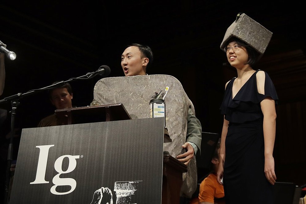 David Hu speaks as Patricia Yang, right, listens as they receive the Ig Nobel award in physics for studying how and why wombats make cubed poo, at the 29th annual Ig Nobel awards ceremony at Harvard University, Thursday, Sept. 12, 2019, in Cambridge, Mass. The spoof prizes for weird and sometimes head-scratching scientific achievement are bestowed by the Annals of Improbable Research magazine, and handed out by real Nobel laureates. (AP Photo/Elise Amendola)