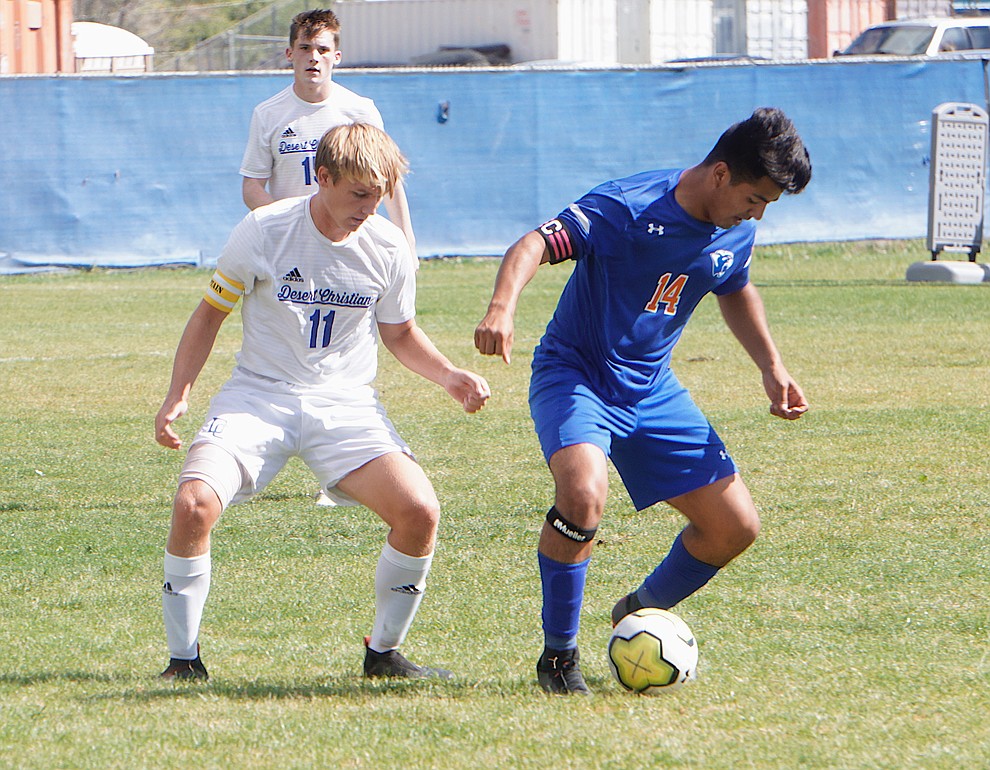 Chino Valley forward Angel Sanchez (14) shield the ball from a defender during the team's 8-2 win over Desert Christian on Saturday, Sept. 28, 2019, at Chino Valley High School. (Aaron Valdez/Courier)