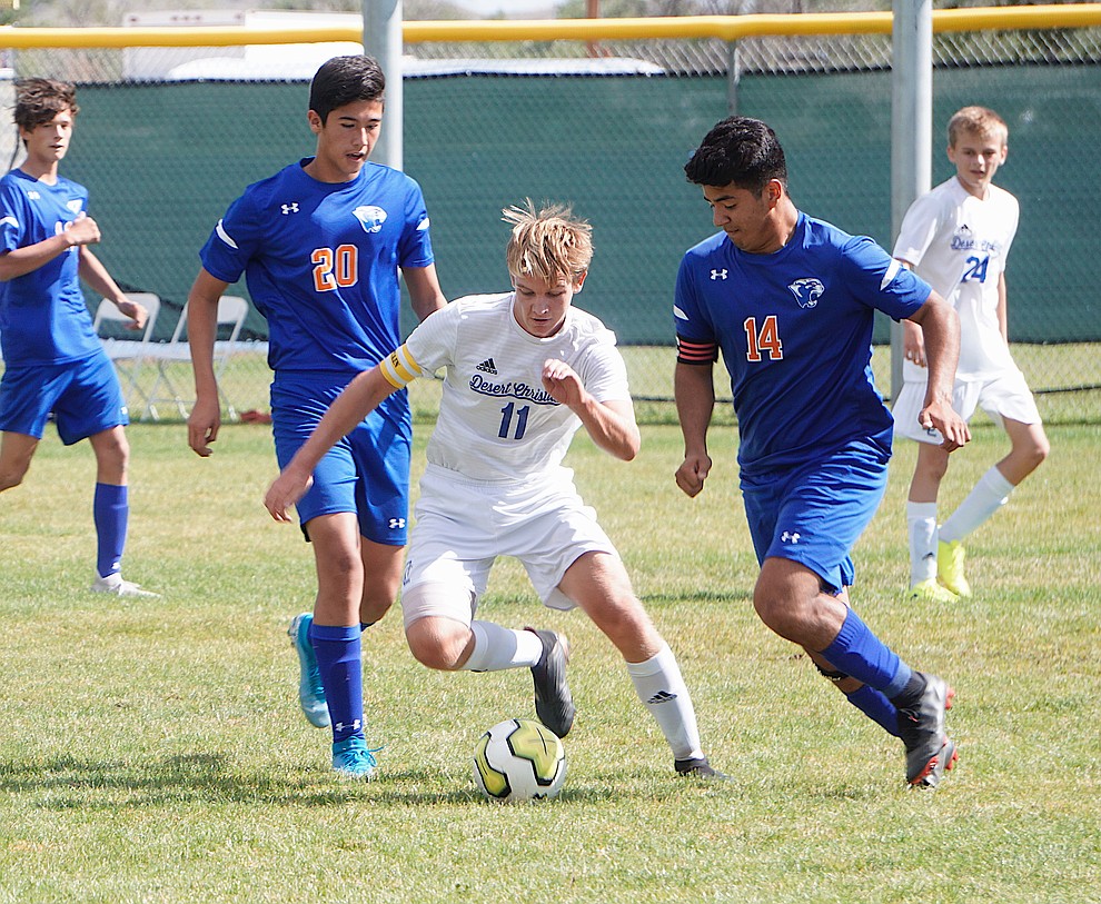 Desert Christian defender Jack Hutton (11) dribbles between Chino Valley's Angel Sanchez (14) and Ricardo Juarez-Flores during a game on Saturday, Sept. 28, 2019, at Chino Valley High School. (Aaron Valdez/Courier)
