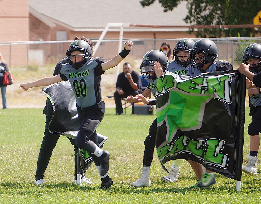 Tommy Dieu (00) of the Prescott Valley Hitmen majors team breaks through the team banner before their game against Bagdad on Saturday, Sept. 28, 2019, at Bradshaw Mountain Middle School. (Aaron Valdez/Courier)