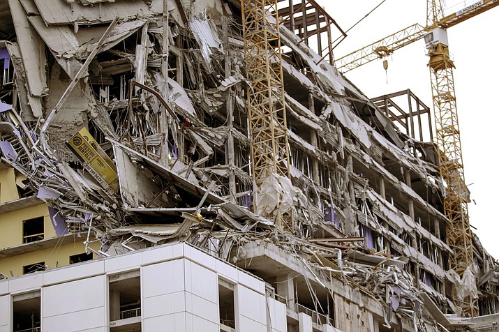 Debris hangs on the side of the building after a large portion of a hotel under construction suddenly collapsed in New Orleans on Saturday, Oct. 12, 2019. Several construction workers had to run to safety as the Hard Rock Hotel, which has been under construction for the last several months, came crashing down. It was not immediately clear what caused the collapse or if anyone was injured. (Scott Threlkeld/The Advocate via AP)