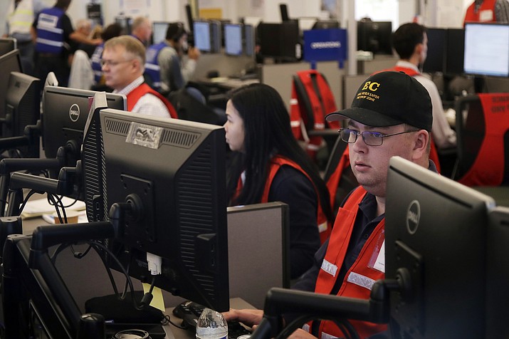 In this Oct. 10, 2019, file photo, Pacific Gas & Electric employees work in the PG&E Emergency Operations Center in San Francisco. Authorities say power outages have started Wednesday, Oct. 23, 2019, in Northern California after the state's largest utility said it was planning a widespread blackout citing wildfire danger. The Santa Rosa Fire Department tweeted Wednesday that shutoffs had started in the city and it was getting multiple reports of outages. Pacific Gas & Electric said earlier Wednesday it was going forward with blackouts later in the day that could affect 450,000 people in 17 counties of Northern California. (AP Photo/Jeff Chiu, File)