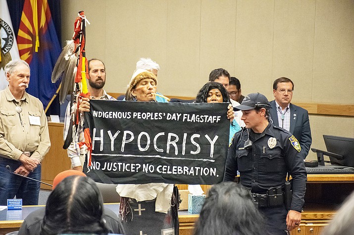 Local activist Klee Benally stands in front of Flagstaff city council members and Flagstaff Mayor Coral Evans as she reads the Indigenous Proclamation Oct. 14. Benally stated that there is . (Photo courtesy of Ralph Schmid)