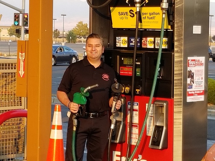 A Prescott Valley Police Department officer poses with gas pumps during the 7th annual Fuel of Dreams at the Fry’s Food Stores in Prescott Valley on Oct. 24, 2019. (PVPD/Courtesy)