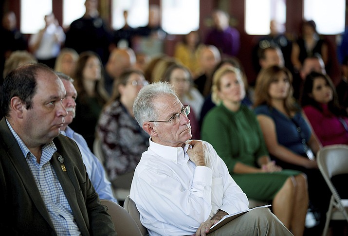 This photo taken Oct. 14, 2019, shows City of Tucson Mayor Jonathan Rothschild, center, listening to the new Tucson Fire Chief, Charles W. Ryan, III, give remarks during a badge pinning ceremony in Tucson, Ariz. (Mamta Popat/Arizona Daily Star via AP)