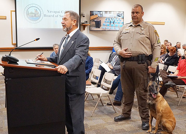 Yavapai County Sheriff Scott Mascher, left, announces the retirement of K9 dog Gemma during a Nov. 6 meeting of the Yavapai County Board of Supervisors, while Gemma’s YCSO officer partner Jarrod Winfrey looks on. (Cindy Barks/Courier)