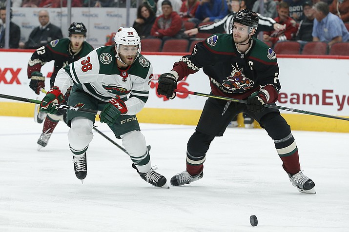 Minnesota Wild right wing Ryan Hartman (38) and Arizona Coyotes defenseman Oliver Ekman-Larsson chase the puck in the first period during a game, Saturday, Nov. 9, 2019, in Glendale (Rick Scuteri/AP)