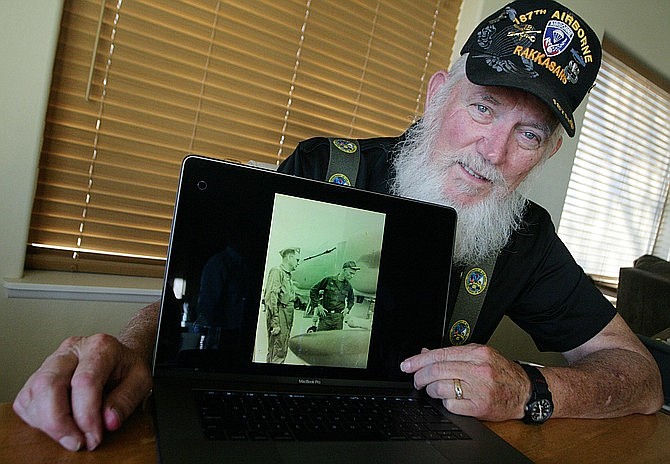 Camp Verde resident Mike Martin looks at a photograph of he and his father, both serving their country in Vietnam, on a laptop computer. Martin has been able to share his Vietnam experience with both his father and his son, Russ. (Bill Helm/VVN)