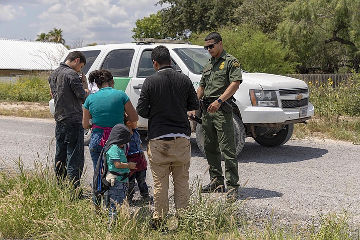 An immigrant family turns itself in to a Border Patrol agent in June after crossing the Rio Grande in June to enter the U.S. illegally. New data who the number of single adult migrants stopped surpassed the number in families for the first time in a year in October. (Photo by Mani Albrecht)