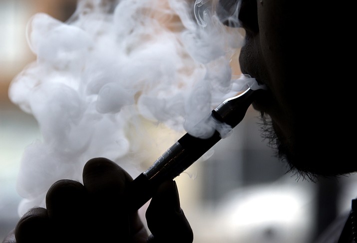 In this April 23, 2014 file photo, a man smokes an electronic cigarette in Chicago. Teen vapers prefer Juul and mint is the #1 flavor among many of them, suggesting a shift after the company’s fruit and dessert flavors were removed from retail stores, new U.S. research suggests. The results are in a pair of studies published Tuesday, Nov. 5, 2019, including a report from the Food and Drug Administration and federal Centers for Disease Control and Prevention indicating that the U.S. teen vaping epidemic shows no signs of slowing down. (AP Photo/Nam Y. Huh, File)