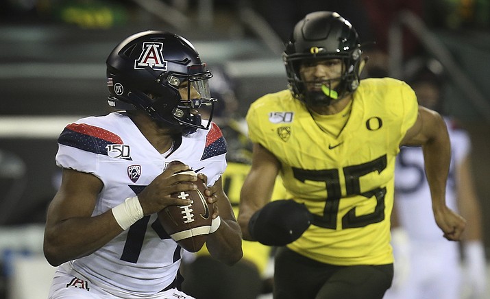 Arizona quarterback Khalil Tate, left, looks for a receiver as Oregon's Troy Dye closes in during the fourth quarter of an NCAA college football game Saturday, Nov. 16, 2019, in Eugene, Ore. (Chris Pietsch/AP, file)