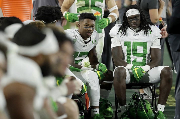 Oregon players sit on the bench during the second half of the team's NCAA college football game against Arizona State, Saturday, Nov. 23, 2019, in Tempe, Ariz. Arizona State won 31-28. (AP Photo/Matt York)