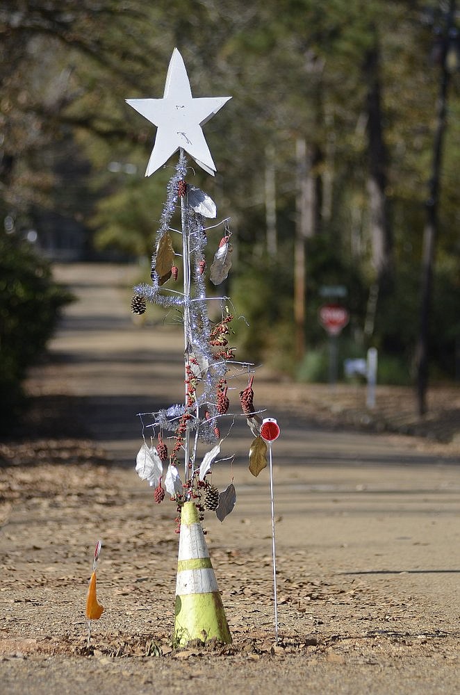 In this Nov. 29, 2019 photo, a decorated road cone stands at a pothole in the Edgewood neighborhood of McComb, Miss. Residents of the Mississippi city are protesting the large pothole in their neighborhood by decorating it with holiday cheer. (Matt Williamson/The Enterprise-Journal via AP)