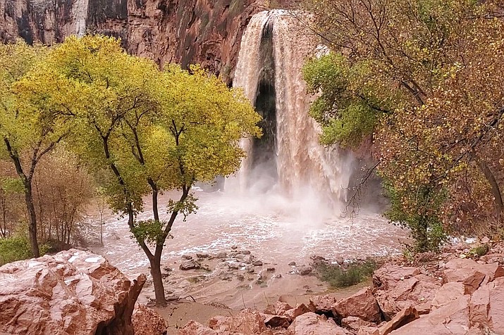 This Nov. 29, 2019, photo, shows a normally blue-green waterfall in Supai, Arizona, that turned chocolate brown after flooding. A popular tourist spot deep in a gorge off the Grand Canyon was flooded over the holiday, sending tourists scrambling to higher ground. The flood happened just days before the Havasupai Tribe shuts down its reservation to tourists for the season. No one was injured but some tourists woke up drenched and some lost camping gear. (Mandy Augustin via AP)