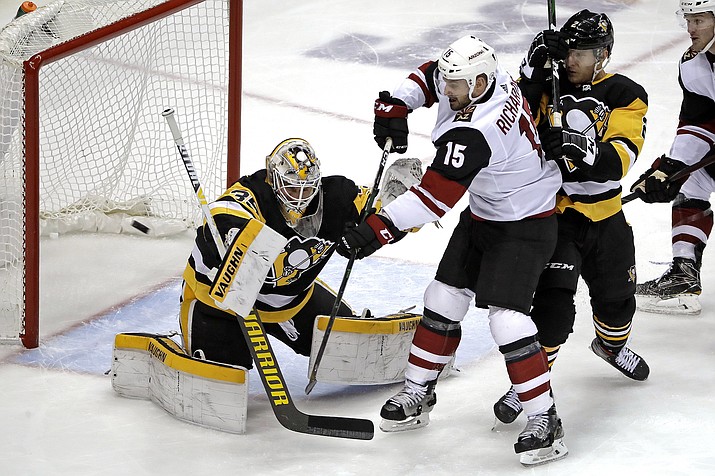 Pittsburgh Penguins goaltender Tristan Jarry (35) blocks a shot deflected by Arizona Coyotes’ Brad Richardson (15) with Penguins’ Chad Ruhwedel defending during the first period of a game in Pittsburgh, Friday, Dec. 6, 2019. (Gene J. Puskar/AP)