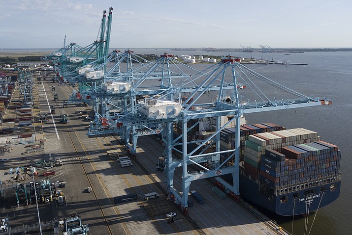 In this Friday, May 10, 2019 file photo, A container ship is unloaded at the Virginia International Gateway terminal in Norfolk, Va.  Defying fears and predictions, the American job market is still shrugging off President Donald Trump’s trade wars. Employers added an impressive 266,000 jobs in November, and unemployment returned to a 50-year low 3.5% _ all at a time when the Trump administration is engaged in a bruising trade war with China while fighting other U.S. trading partners as well. (Steve Helber/AP, file)