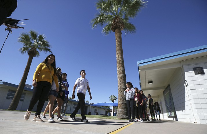 File - In this Oct. 17, 2019, file photo, Students walk to class on campus at Valencia Newcomer School in Phoenix. The school is among a handful of such public schools in the United States dedicated exclusively to helping some of the thousands of children who arrive in the country annually. Arizona Gov. Doug Ducey told President Donald Trump's administration Friday, Dec. 6, 2019, the state will continue its tradition of welcoming refugees, cheering resettlement agencies that have lobbied the state and local governments to keep opening their arms to people fleeing war and other horrific situations in their native countries. (AP Photo/Ross D. Franklin, File)