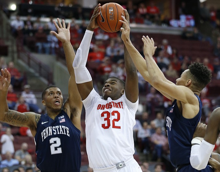 Ohio State's E.J. Liddell, center, grabs a rebound in between Penn State's Myles Dread, left, and Seth Lundy during the second half of an NCAA college basketball game Saturday, Dec. 7, 2019, in Columbus, Ohio. Ohio State beat Penn State 104-74. (AP Photo/Jay LaPrete)