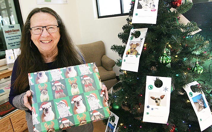 Camp Verde Librarian Alice Gottschalk holds one of the gifts at the giving tree sponsored by the library and the Verde Valley Humane Society. Visit one of four VVHS Giving Tree locations and choose a dog or cat gift tag from the tree. VVN/Bill Helm