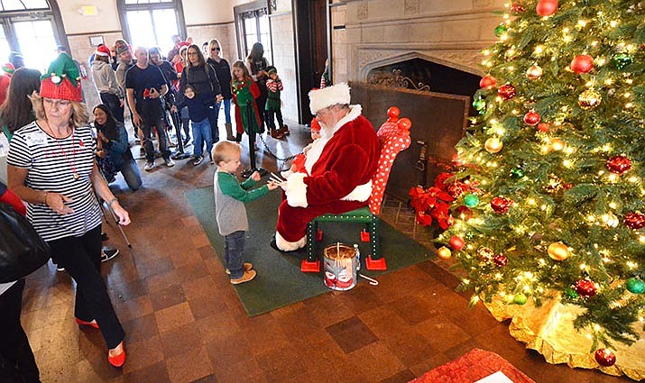 Jaxx Douglas, 3, gets a candy cane from Santa after telling him what he wants for Christmas on Saturday in Clarkdale. VVN/Vyto Starinskas