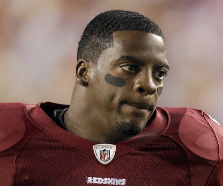 This Sept. 12, 2010, file photo shows Washington Redskins running back Clinton Portis before the start of an NFL football game against the Dallas Cowboys, in Landover, Md. Ten former NFL players have been charged with defrauding the league’s healthcare benefit program. They include five who played on the Washington Redskins, including Clinton Portis and Carlos Rogers. (Rob Carr/AP, file)