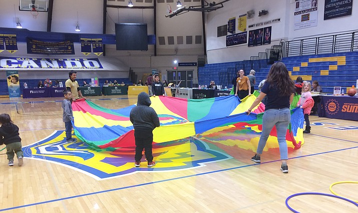Children play a parachute game during the wellness fair on Wednesday, Dec. 11, 2019. (Nanci Hutson/Courier)