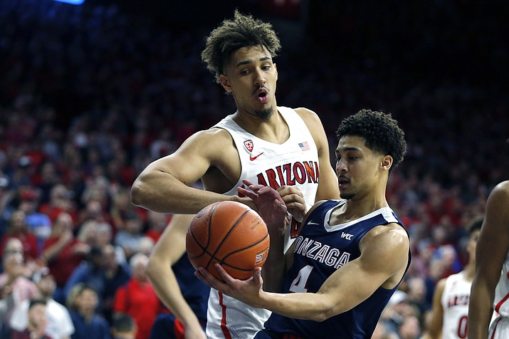 Arizona center Chase Jeter and Gonzaga guard Ryan Woolridge (4) fight for a loose ball in the first half of a game, Saturday, Dec. 14, 2019, in Tucson. (Rick Scuteri/AP)