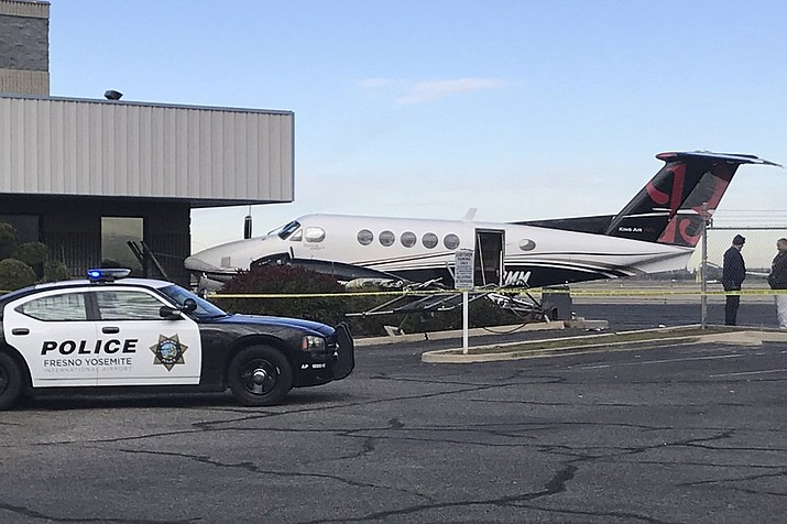 A small plane sits parked after it was crashed into a fence by a 17-year-old girl Wednesday, Dec. 18, 2019, at the Fresno Yosemite International Airport in Fresno, Calif. A spokeswoman for the airport told The Fresno Bee that the teenager breached the fence, started up the plane and crashed it into a fence Wednesday. Airport officials say officers found the teen in the pilot's seat, wearing the headset. No one was injured. The teen was arrested on suspicion of theft of an aircraft. (Jim Guy/The Fresno Bee via AP)