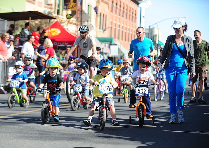 Children and caregivers (above) ride down a street in Prescott during a past city event. (Courier file)