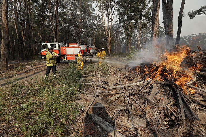 Firefighters battles a fire near Bendalong, Australia, Friday, Jan. 3, 2020. Navy ships plucked hundreds of people from beaches and tens of thousands were urged to flee before hot, windy weather worsens Australia's devastating wildfires. (Rick Rycroft/AP)