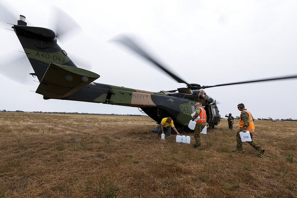 In this photo provided by the Australian Department of Defence, a Royal Australian Navy helicopter is loaded with supplies at Bairnsdale for the fire impacted community of Cann River Sunday, Jan. 5, 2020. The wildfires have so far scorched an area twice the size of the U.S. state of Maryland. (Private Michael Currie/ADF via AP)