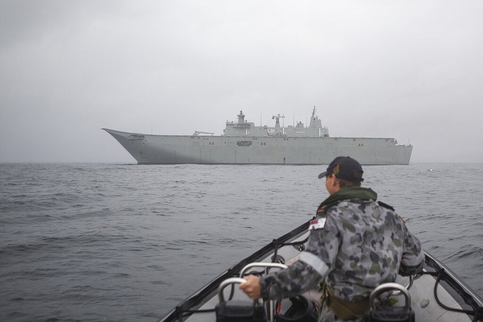 In this photo provided by the Australian Department of Defence on Jan. 6, 2020, HMAS Adelaide is anchored off Eden and is positioned to assist with wildfires. The wildfires have so far scorched an area twice the size of the U.S. state of Maryland. They have destroyed about 2,000 homes. (Able Seaman Thomas Sawtell/ADF via AP)
