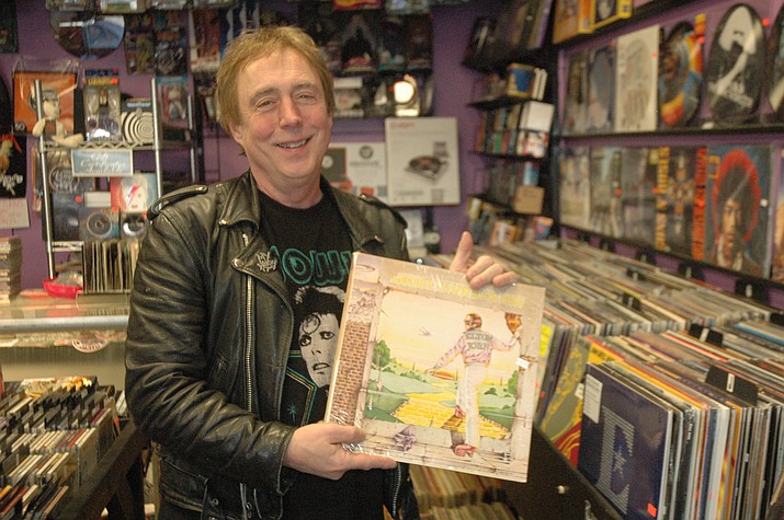Daryl Halleck, owner of Trax Records in downtown Prescott, points out some of the more popular rock albums in his store. (Jason Wheeler/Courier)