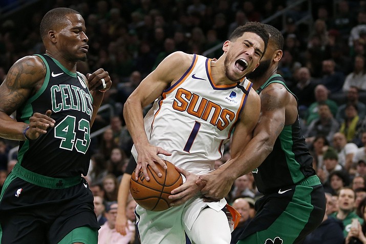 Phoenix Suns guard Devin Booker (1) yells as he drives to the basket between Boston Celtics guard Javonte Green (43) guard Brad Wanamaker (9) during the first half of a game, Saturday, Jan. 18, 2020, in Boston. (Mary Schwalm/AP)