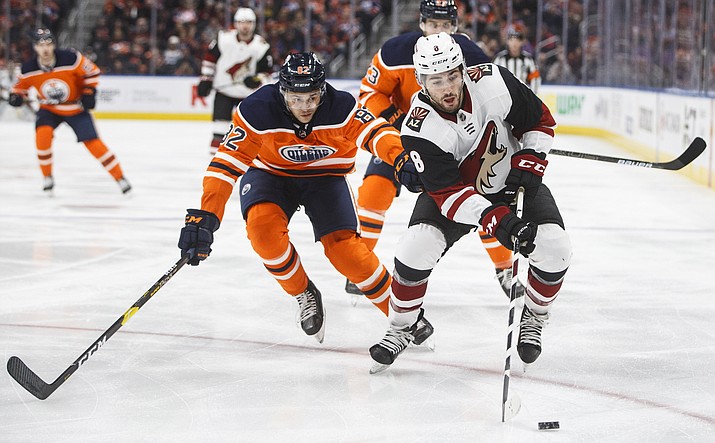 Arizona Coyotes’ Nick Schmaltz (8) is chased by Edmonton Oilers’ Caleb Jones (82) during first period of a game in Edmonton, Alberta, on Saturday Jan. 18, 2020. (Jason Franson/The Canadian Press via AP)