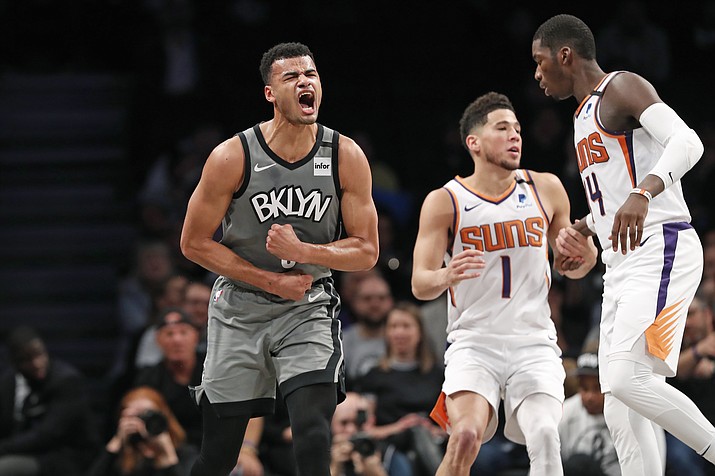 Brooklyn Nets guard Timothe Luwawu-Cabarrot, left, reacts after he was knocked down by Phoenix Suns guard Devin Booker (1) during the second quarter of an NBA basketball game, Monday, Feb. 3, 2020, in New York. Suns forward Cheick Diallo (14) is at right. (Kathy Willens/Ap)