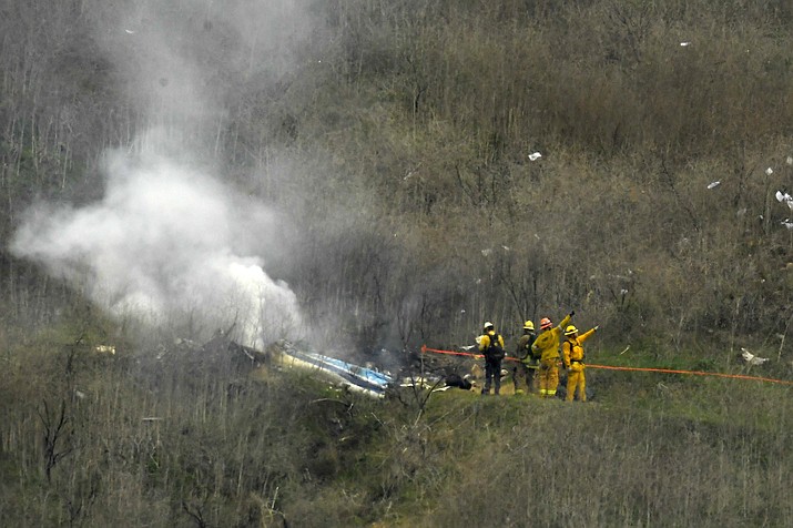 In this Jan. 26, 2020 file photo firefighters work the scene of a helicopter crash where former NBA star Kobe Bryant died, in Calabasas, Calif. Federal investigators say wreckage from the helicopter that crashed last month and killed Bryant, his daughter and seven others did not show any outward evidence of engine failure, the National Transportation Safety Board said Friday, Feb. 7, 2020. (Mark J. Terrill/AP, file)