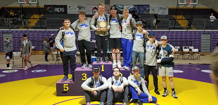 Chino Valley wrestling poses for a photo in front of the podium after taking first place at Sectionals on Saturday, Feb. 8, 2020, in Payson. (Kevin Giese/Courtesy)
