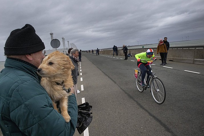 A competitor battles gale force winds during the Dutch Headwind Cycling Championships on the storm barrier Oosterscheldekering near Neeltje Jans, south-western Netherlands, Sunday, Feb. 9, 2020. (AP Photo/Peter Dejong)