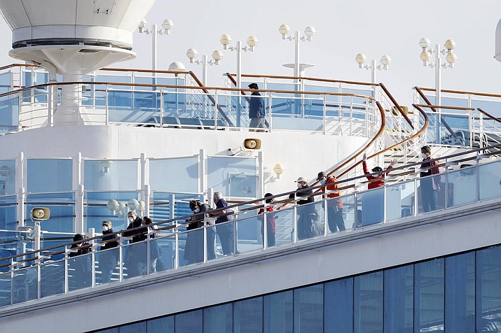 Passengers stand on the deck of the Diamond Princess cruise ship anchored at Yokohama Port in Yokohama, near Tokyo, Wednesday, Feb. 12, 2020. Japan’s health ministry said Wednesday that 39 new cases of a virus have been confirmed on the cruise ship quarantined at the Japanese port. (Yuta Omori/Kyodo News via AP)